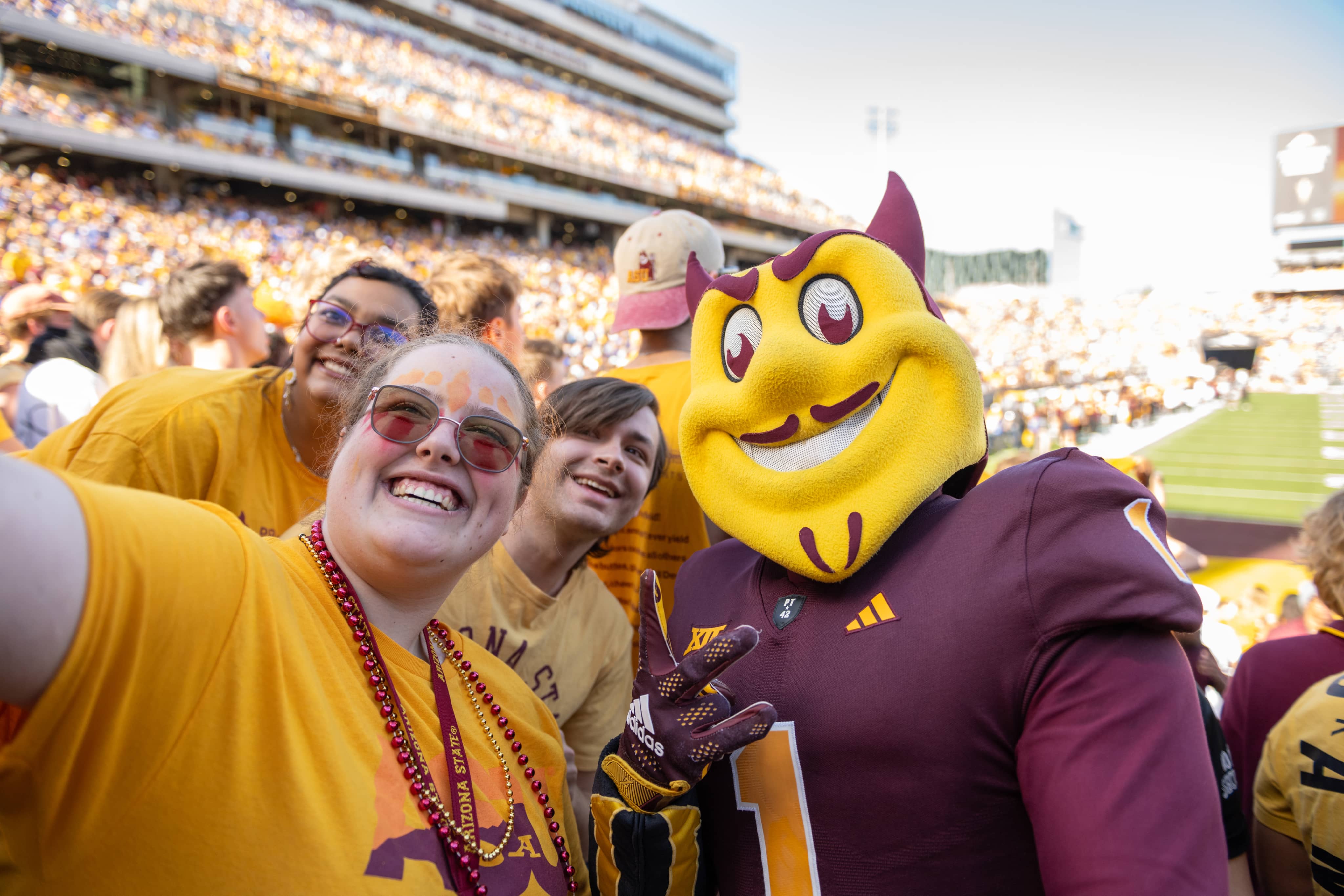 Sparky posing with fans at a football game