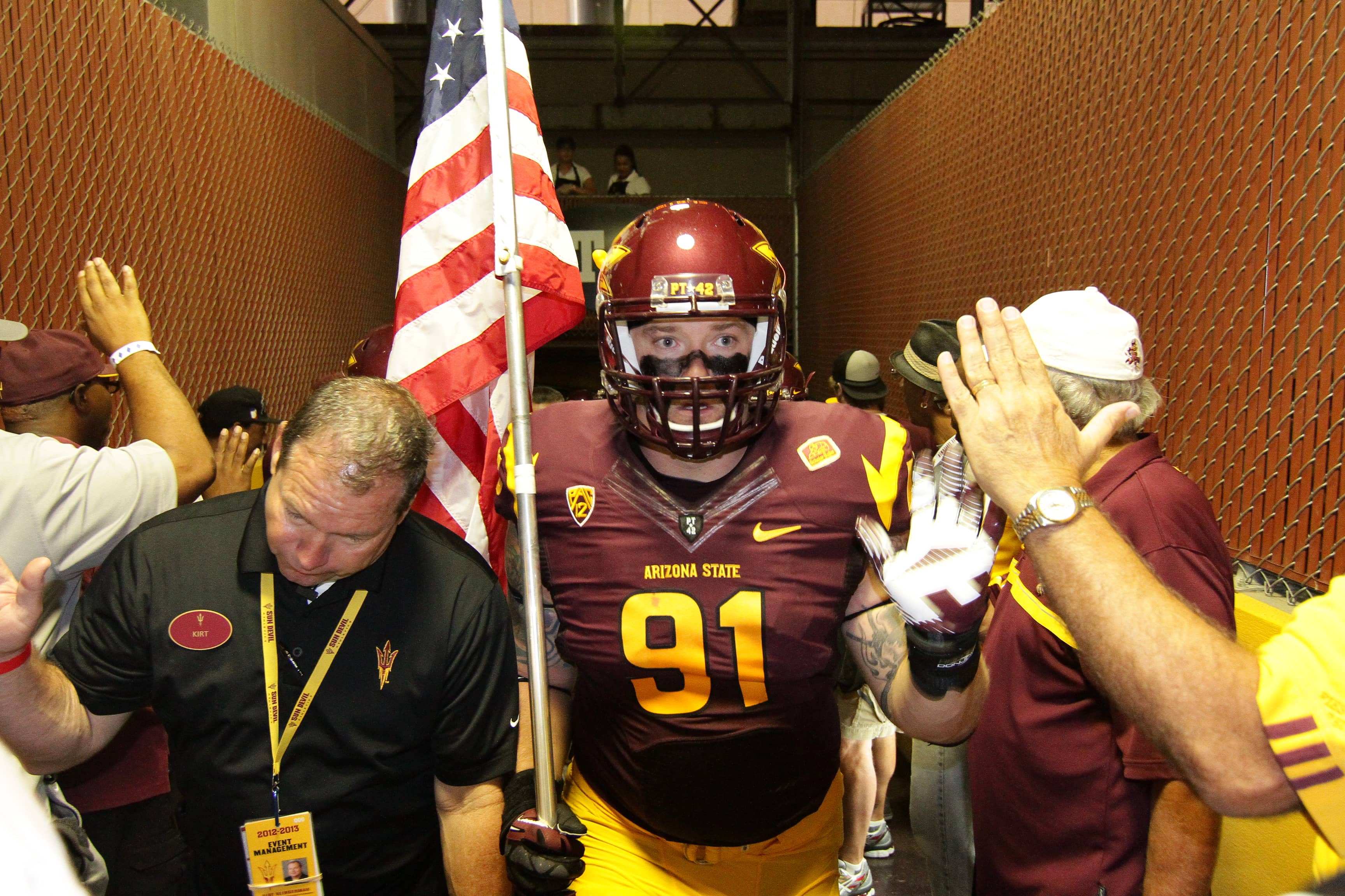 Jake Sheffield in tunnel before football game with ameican flag