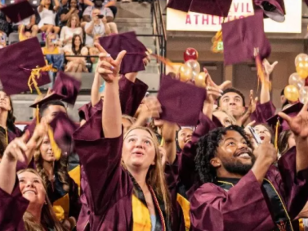 ASU Graduates throwing cap in the air