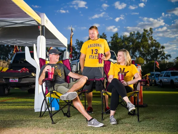 Family and friends wearing ASU gear at a tailgate before a football game enjoying pregame festivities