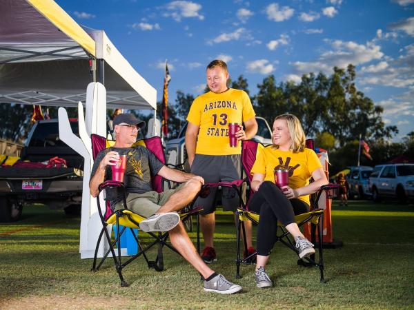 Family and friends in ASU gear at a tailgate enjoying pregame festivities.